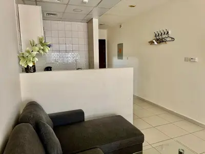 a waiting room with a couch and flowers on the wall at Not far from metro and WTC in Dubai