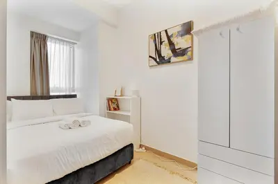 a white bedroom with a white bed and a window at Modern 3BR with City Views and a Spacious Layout in Dubai