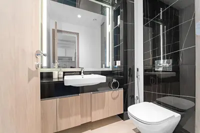 a bathroom with a white toilet and a sink at Modern 3BR with City Views and a Spacious Layout in Dubai