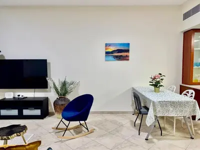a living room with a table and a tv at Motor City Norton Court Parking Pool in Dubai