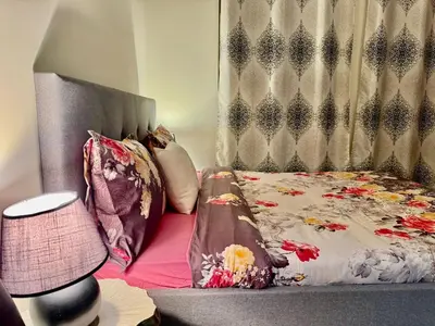 a bedroom with a bed with a headboard and pillows at Motor City Norton Court Parking Pool in Dubai