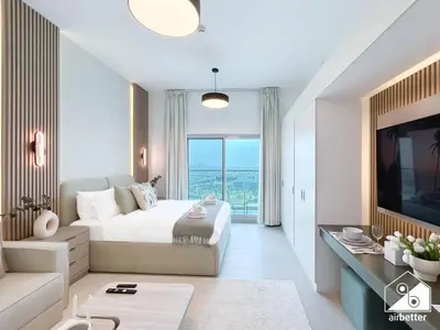 a bedroom with a large bed and a large window at High-End Studio l Pool & Gym Included in Dubai
