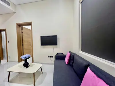 a living room with a blue couch and a tv at Karama Palace Home in Dubai