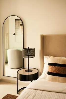 a bedroom with a mirror and a bed with a lamp at Luxury 58th Floor Seaview 2BR - Paramount Midtown - 6 Guests - 64F Pool Access & Burj View in Dubai
