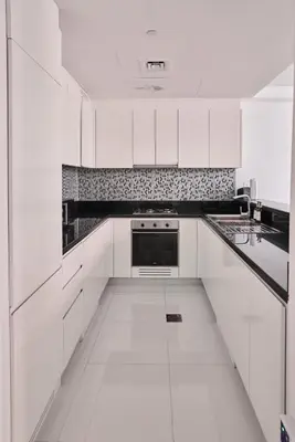 a white kitchen with white cabinets and a sink at Luxury 58th Floor Seaview 2BR - Paramount Midtown - 6 Guests - 64F Pool Access & Burj View in Dubai