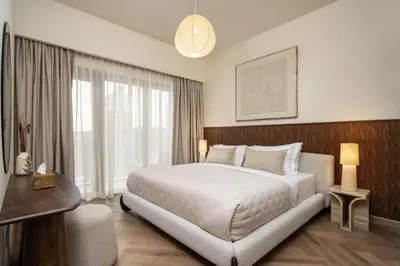 a bedroom with a large bed and a large window at Seraya Residences at Burj Royale in Dubai