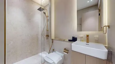 a bathroom with a toilet and a sink and a shower at Dusk By Binghatti - Dazzling Studio in JVC in Dubai