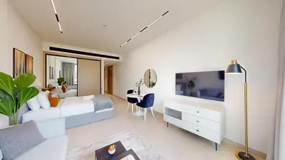 a bedroom with a bed and a tv and a desk at Dusk By Binghatti - Dazzling Studio in JVC in Dubai