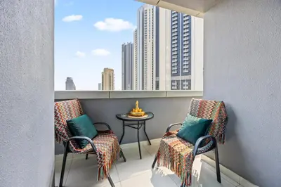 a balcony with two chairs and a table with a city view at 1BR Full Burj View 1 min to Dubai Mall Arabic Vibe in Dubai