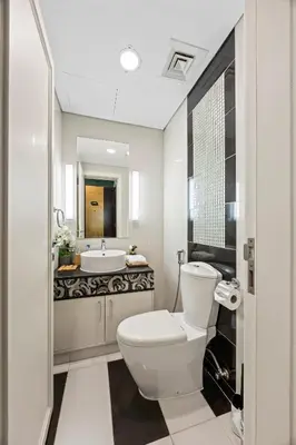 a white bathroom with a toilet and a sink at 1BR Full Burj View 1 min to Dubai Mall Arabic Vibe in Dubai