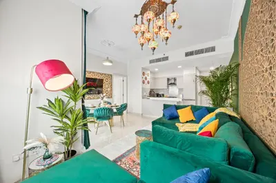 a living room with a green couch and a dining room at 1BR Full Burj View 1 min to Dubai Mall Arabic Vibe in Dubai