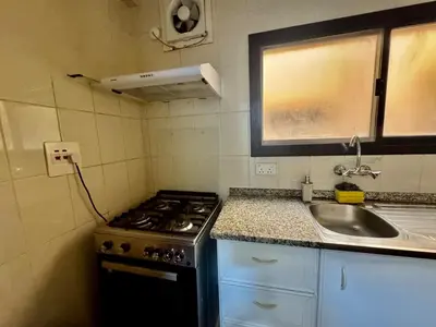 a small kitchen with a stove and a sink at Spacious & cozy home 2-Bedroom in Dubai