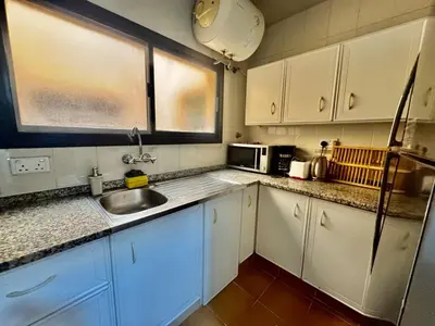 a kitchen with white cabinets and a sink at Spacious & cozy home 2-Bedroom in Dubai