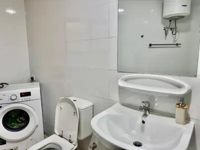 a bathroom with a toilet and a washing machine at Spacious & cozy home 2-Bedroom in Dubai