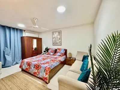 a bedroom with a bed and a couch at Spacious & cozy home 2-Bedroom in Dubai