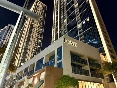 a building with a sign on it in front of tall buildings at Serenity Suite Stylish 2BR Pool & Fitness Perks in Dubai