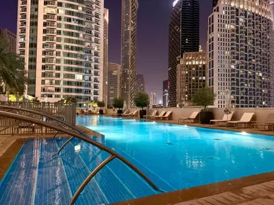 a large swimming pool in a city with tall buildings at Serenity Suite Stylish 2BR Pool & Fitness Perks in Dubai
