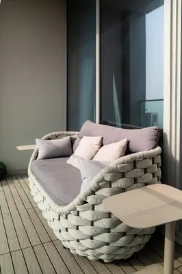 a wicker couch in a room with a window at Serenity Suite Stylish 2BR Pool & Fitness Perks in Dubai