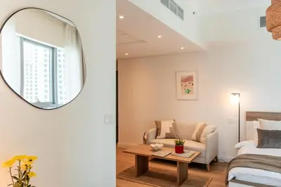 a bedroom with a bed and a mirror at Cozy Marina Studio, Canal View with a Balcony in Dubai