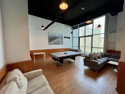 a large living room with a pool table in it at Cozy Marina Studio, Canal View with a Balcony in Dubai