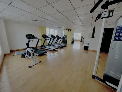 a gym with rows of treadmills and elliptical machines at Cozy Marina Studio, Canal View with a Balcony in Dubai