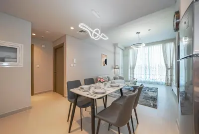 a dining room and living room with a table and chairs at Luxurious 1BR Apartment in Harbour Gate in Dubai