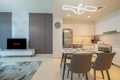 a kitchen and dining room with a table and chairs at Luxurious 1BR Apartment in Harbour Gate in Dubai