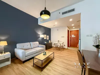 a living room with a couch and a table at Rare Holiday Homes - Near City Center Ma'eisem - Lake view - Crescent Tower C - R806 - IMPZ in Dubai