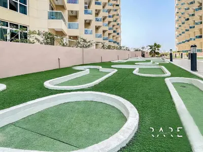 a grassy area with white numbers on top of it at Rare Holiday Homes - Near City Center Ma'eisem - Lake view - Crescent Tower C - R806 - IMPZ in Dubai