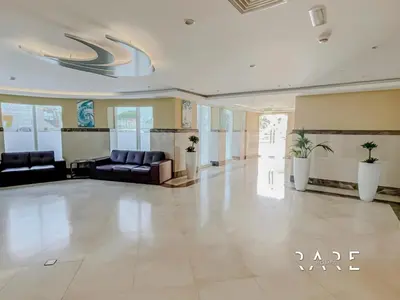 a lobby with couches and chairs in a building at Rare Holiday Homes - Near City Center Ma'eisem - Lake view - Crescent Tower C - R806 - IMPZ in Dubai