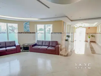 a lobby with two purple couches in a room at Rare Holiday Homes - Near City Center Ma'eisem - Lake view - Crescent Tower C - R806 - IMPZ in Dubai