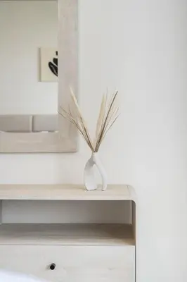 a white dressing table with a mirror and a vase at Airstay - Minimalist 1BR - EMAAR Beachfront - Monthly Offer Available in Dubai
