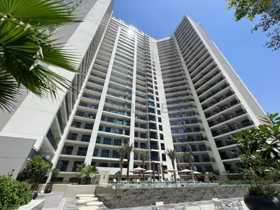 a large white building with umbrellas in front of it at Facing the Dubai Water Canal 1BR, Minutes from Metro with Easy Downtown Access, Zada Tower, Business Bay by Deluxe Holiday Homes in Dubai