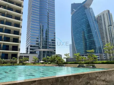 a swimming pool in a city with tall buildings at Facing the Dubai Water Canal 1BR, Minutes from Metro with Easy Downtown Access, Zada Tower, Business Bay by Deluxe Holiday Homes in Dubai