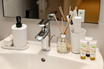a bathroom counter withbranded products on a sink at Burj View Stylish 3BR with Maids Room in Act One Tower Downtown in Dubai