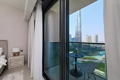 a bedroom with a balcony with a view of the city at Burj View Stylish 3BR with Maids Room in Act One Tower Downtown in Dubai