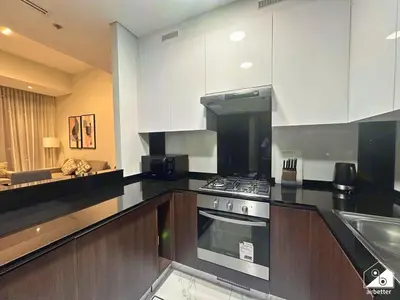 a kitchen with white cabinets and a stove top oven at Chic 1BR in Business Bay l Pool, Gym & Sauna in Dubai