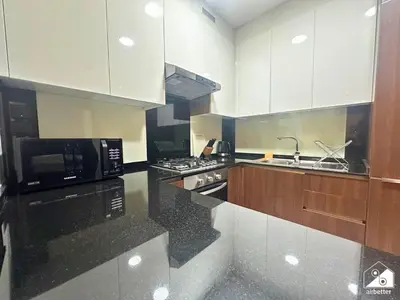 a kitchen with white cabinets and black counter tops at Chic 1BR in Business Bay l Pool, Gym & Sauna in Dubai