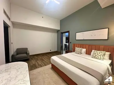 a bedroom with a large bed and a chair at Stylish 1BR Stay l Rooftop Pool, Sauna & Gym in Dubai