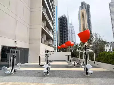 a building with fitness equipment in a city at Vogue Downtown Mag 318 near Burj Khalifa and Dubai Mall, Studio Apartment with Balcony, Canal and City View, Access to all Amenities in Dubai