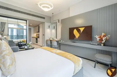 a bedroom with a large bed and a living room at Vogue Downtown Mag 318 near Burj Khalifa and Dubai Mall, Studio Apartment with Balcony, Canal and City View, Access to all Amenities in Dubai