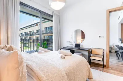 a bedroom with a bed and a desk and a window at New Luxury 2 Bedroom with Padel Gym Pool Cinema BBQ in Dubai