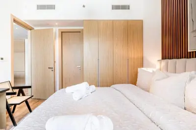 a bedroom with a large white bed with towels on it at New Luxury 2 Bedroom with Padel Gym Pool Cinema BBQ in Dubai