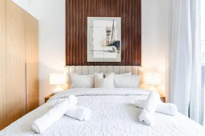 a bedroom with a large white bed with white pillows at New Luxury 2 Bedroom with Padel Gym Pool Cinema BBQ in Dubai