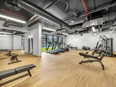 a gym with several treadmills and exercise machines at New Luxury 2 Bedroom with Padel Gym Pool Cinema BBQ in Dubai