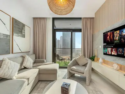 a living room with a couch and a tv at Mahogany 16 - 1BR 4 Guests - Walk to Burj Khalifa in Dubai