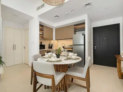 a kitchen with a table with chairs and a refrigerator at Mahogany 16 - 1BR 4 Guests - Walk to Burj Khalifa in Dubai