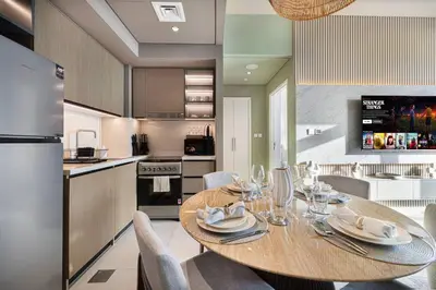a kitchen and dining room with a wooden table and chairs at Mahogany 15 - 1BR 4 Guests - Walk to Burj Khalifa in Dubai