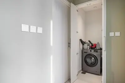 a laundry room with a washing machine in a closet at Mahogany 15 - 1BR 4 Guests - Walk to Burj Khalifa in Dubai