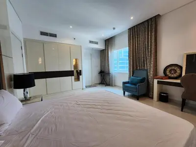 a large bedroom with a large bed and a chair at Modern Monastery 1 BR Business Bay in Dubai